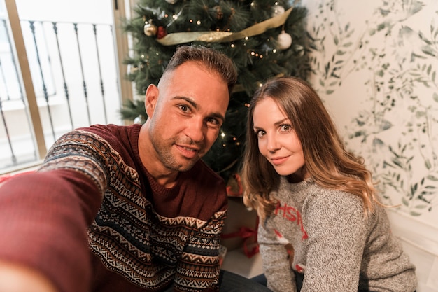 Hombre y mujer, toma, selfie, cerca, árbol de navidad