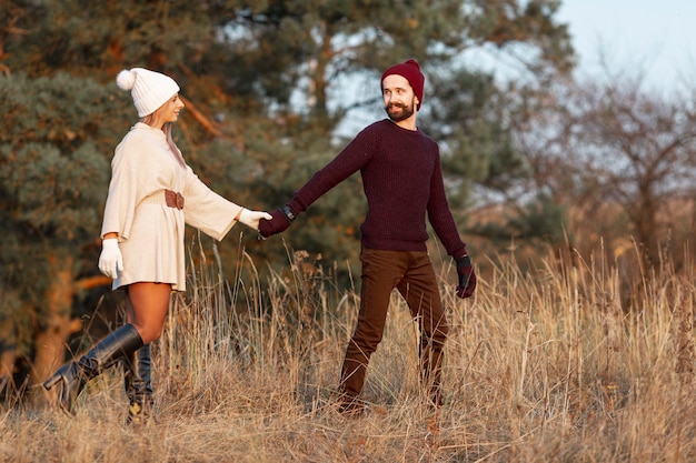 Hombre y mujer tomados de la mano afuera