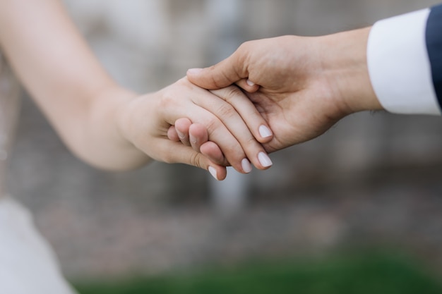 Hombre y mujer se toman de las manos juntos al aire libre