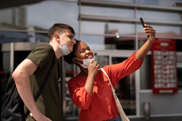 Hombre y mujer tomando selfie fuera del supermercado