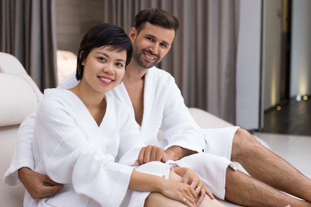 Hombre y mujer tumbados con batas blancas