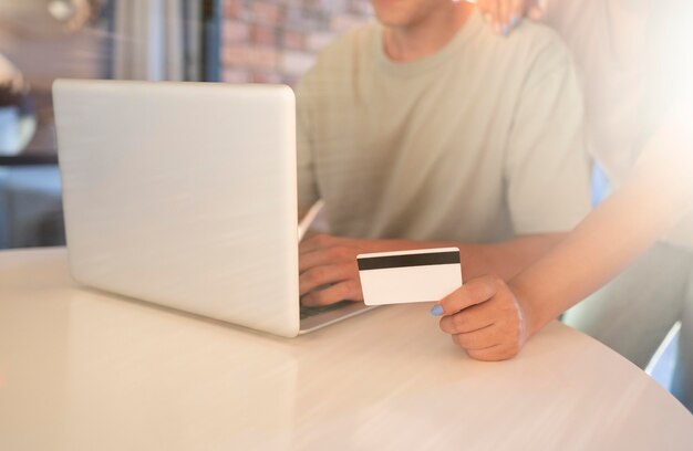 Hombre y mujer usando laptop para compras en línea con tarjeta de crédito