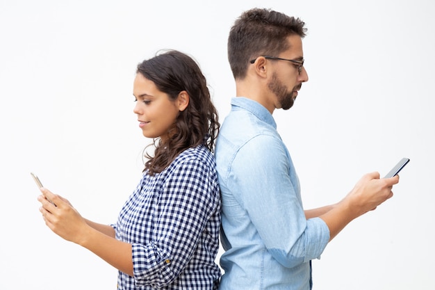 Foto gratuita hombre y mujer usando teléfonos inteligentes