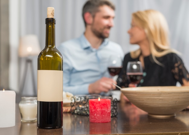 Foto gratuita hombre y mujer con vasos en la mesa con botella y tazón