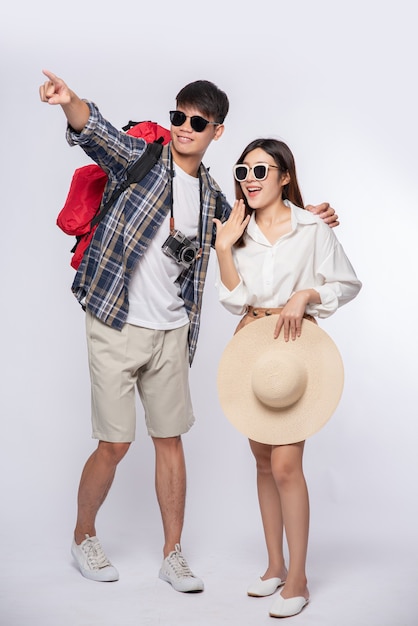 Hombre y mujer vestidos con gafas para viajar con maletas