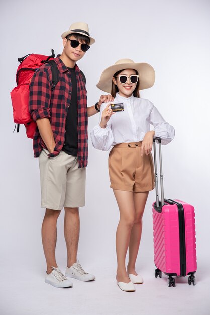 Hombre y mujer vestidos con gafas para viajar con maletas