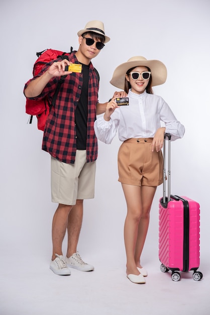 Hombre y mujer vestidos con gafas para viajar con maletas