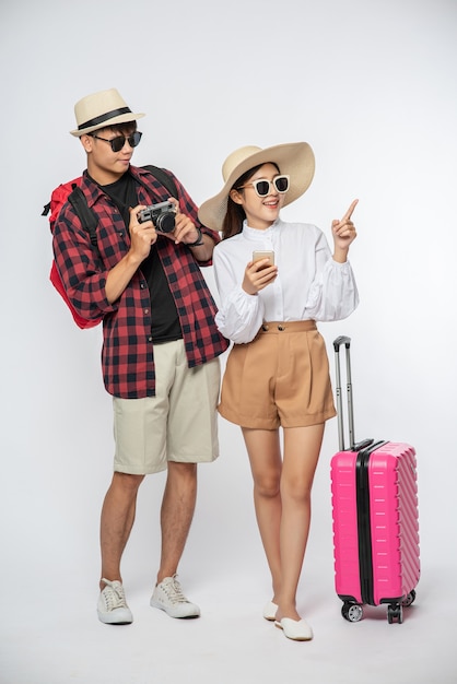 Hombre y mujer vestidos para viajar, usar gafas y tomar fotografías