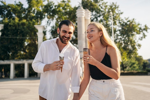 Hombre y mujer de vista frontal disfrutando de un helado en el parque