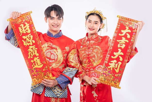 Hombre y mujer visten traje Cheongsam celebran el año nuevo chino con una tarjeta de felicitación china
