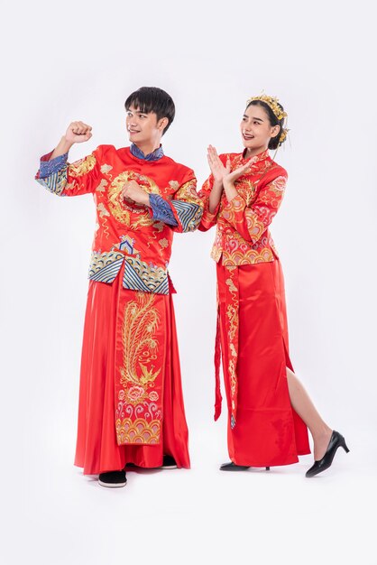 Hombre y mujer visten traje Cheongsam contentos de que el evento se lleve a cabo el año nuevo chino