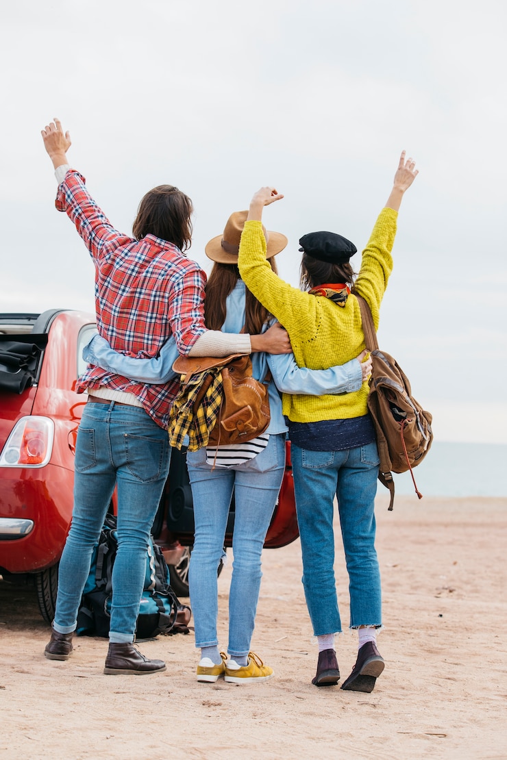 Foto gratuito hombre y mujeres abrazando cerca de coche en la playa del mar