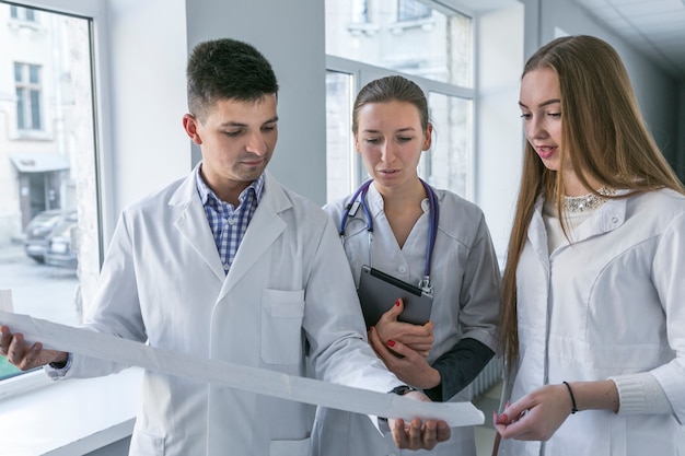 Hombre y mujeres doctores viendo cardiograma