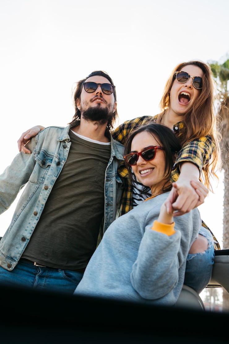 Foto gratuito hombre y mujeres sonrientes abrazándose, divirtiéndose y echándose del auto