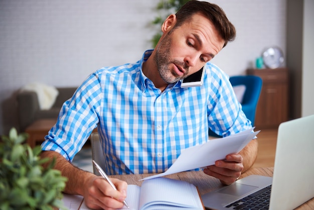 Foto gratuita hombre multitarea que trabaja en la oficina en casa