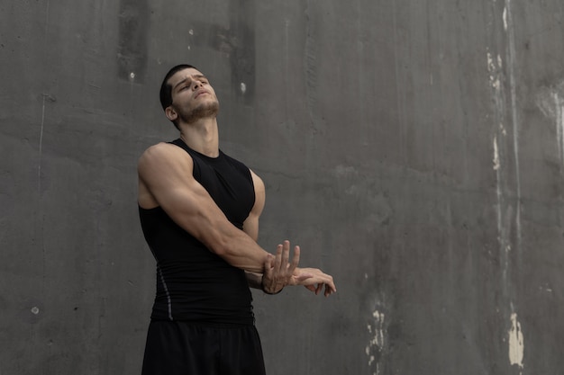 Hombre musculoso y deportivo fuerte calentando, preparándose para entrenar