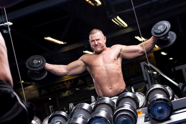 Foto gratuita hombre musculoso en un gimnasio