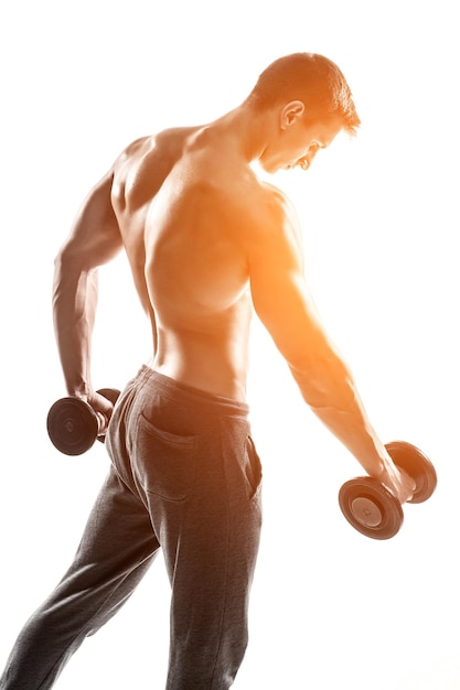 Foto gratuita hombre musculoso guapo haciendo ejercicios con pesas aislado sobre fondo blanco con llamarada solar