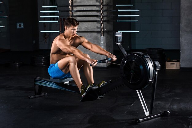 Hombre musculoso haciendo ejercicios para las piernas en el gimnasio. El atleta está en buena forma. Entrenador personal