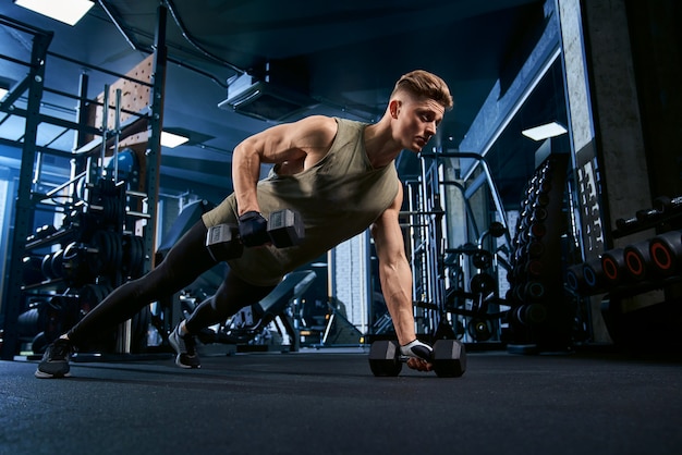 Hombre musculoso haciendo flexiones por un lado.