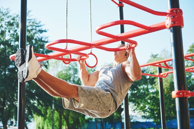 Foto gratuita hombre musculoso con hermoso torso haciendo ejercicio en barras horizontales