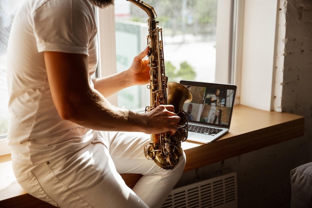 Hombre músico caucásico durante el concierto en línea en casa aislado y en cuarentena,