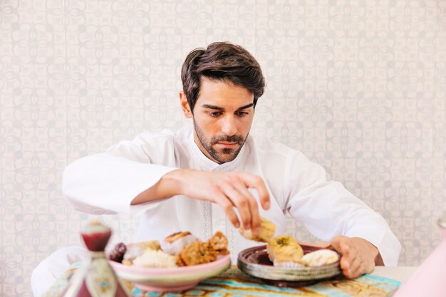 Hombre musulmán comiendo comida arabe