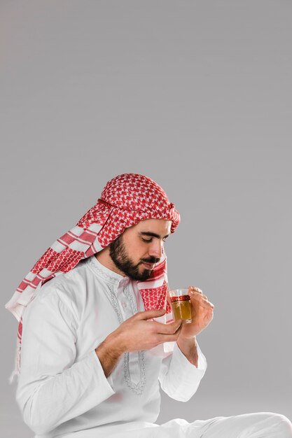 Hombre musulmán sonriente disfruta retrato tradicional de té