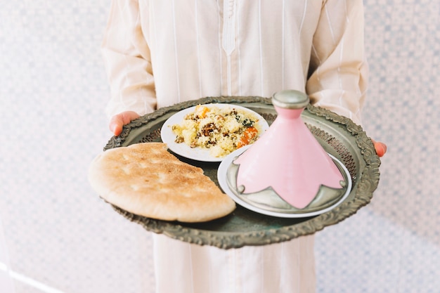 Foto gratuita hombre musulmán sujetando plato de comida