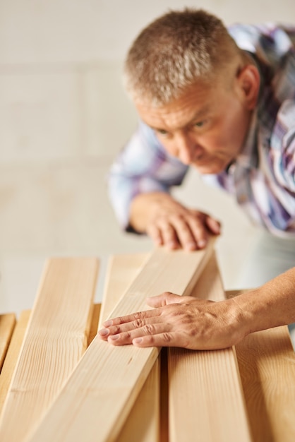 Foto gratuita hombre muy trabajador meausers otros tablones de madera