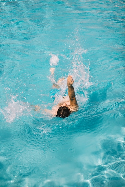 Hombre nadando braza de espalda en agua