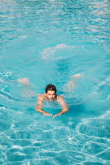 Hombre nadando en piscina refrescante