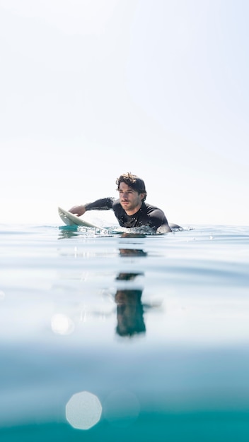 Foto gratuita hombre nadando en tabla de surf