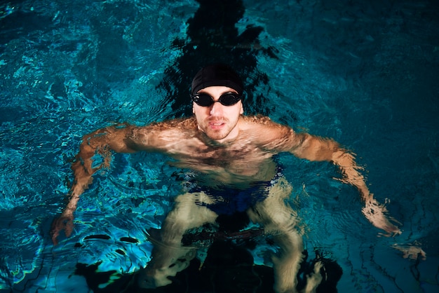 Hombre de natación de alto ángulo en cuenca