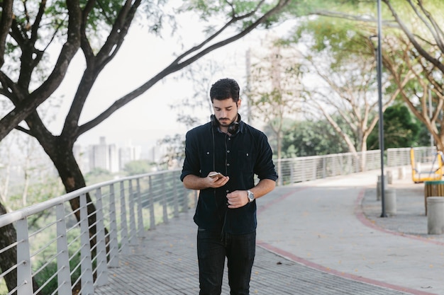 Hombre navegación smartphone en el parque