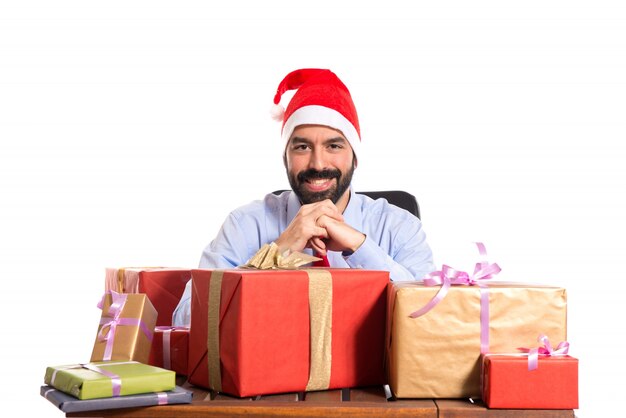 Hombre de Navidad en su oficina con varios regalos