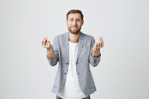 Foto gratuita hombre necesitado pidiendo prestado dinero, frunciendo el ceño