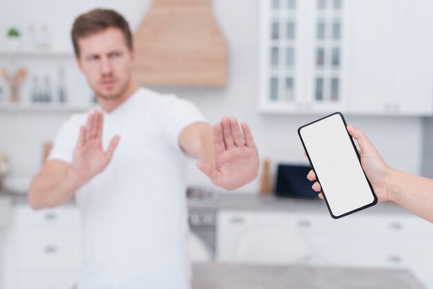 Hombre negándose a sostener un teléfono