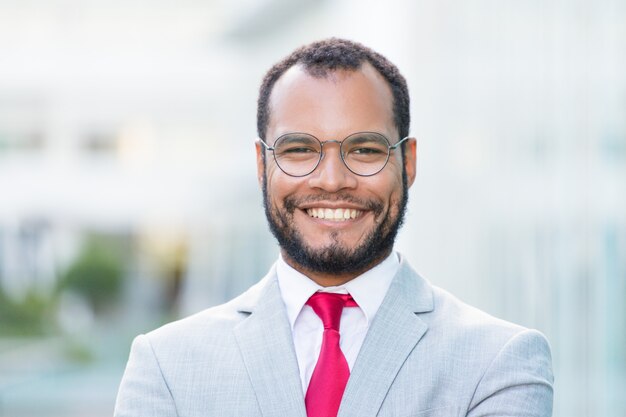 Hombre de negocios acertado feliz que presenta afuera