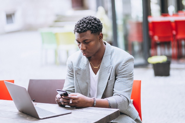 Hombre de negocios afroamericano usando laptop en un café