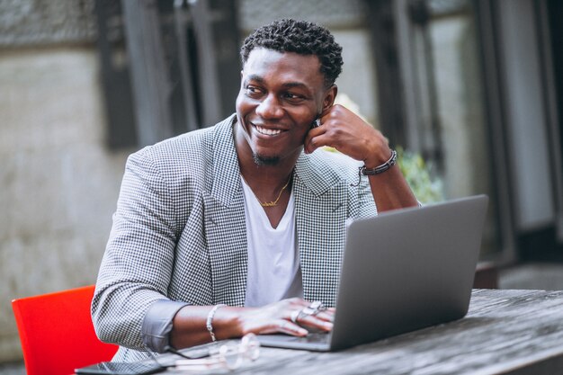 Hombre de negocios afroamericano usando laptop en un café