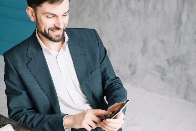 Hombre de negocios alegre con smartphone