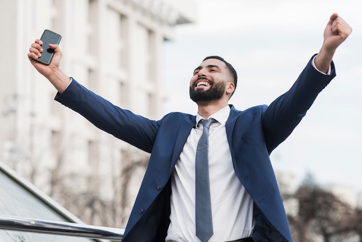 Foto gratuito hombre de negocios de ángulo bajo feliz