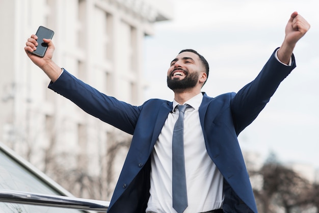 Hombre de negocios de ángulo bajo feliz