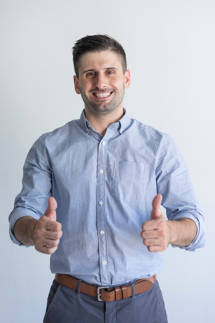 Foto gratuito hombre de negocios atractivo acertado alegre con rastrojo que muestra el pulgar hacia arriba