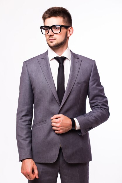 Hombre de negocios atractivo de pie con traje azul y corbata, con gafas. Fondo blanco.