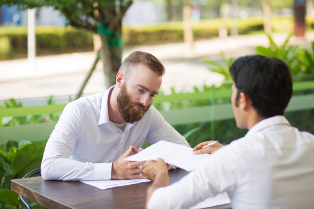 Hombre de negocios barbudo descontento reunido con asesor financiero