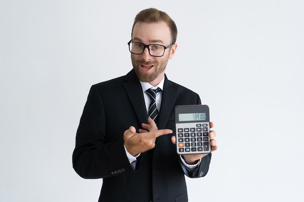 Hombre de negocios barbudo emprendedor que señala en la calculadora