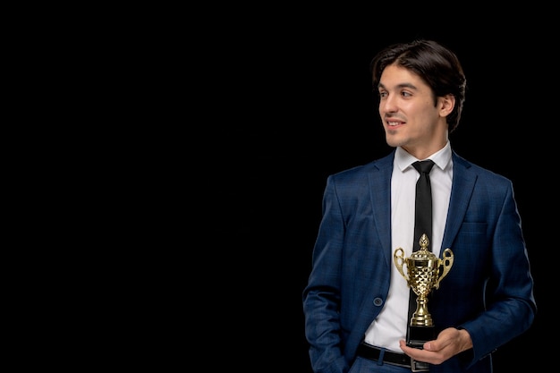 Foto gratuita hombre de negocios bastante joven en traje azul oscuro con la corbata con premio de oro