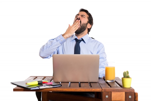 Foto gratuita hombre de negocios bostezando en su oficina